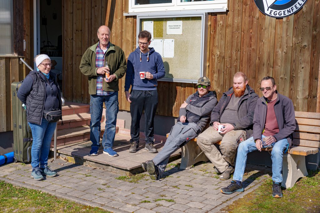 Mitglieder machen auf der Sitzbank vor dem Vereinsheim eine Pause von der Arbeit